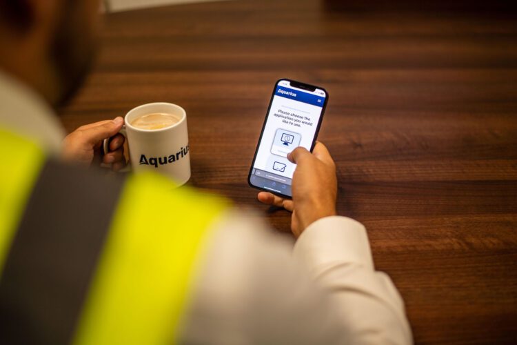 Hand Holding Phone With The Aquarius IT App Open
